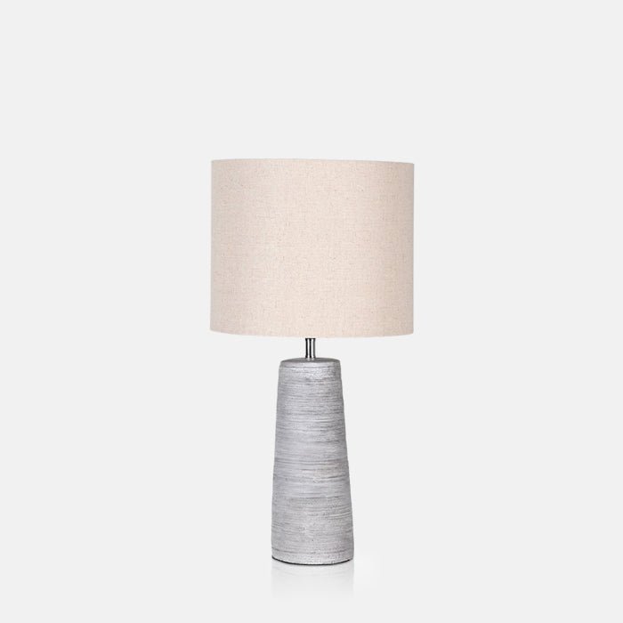 A cutout of the Fria Table Lamp, with white-wash look base and cream drum shade.