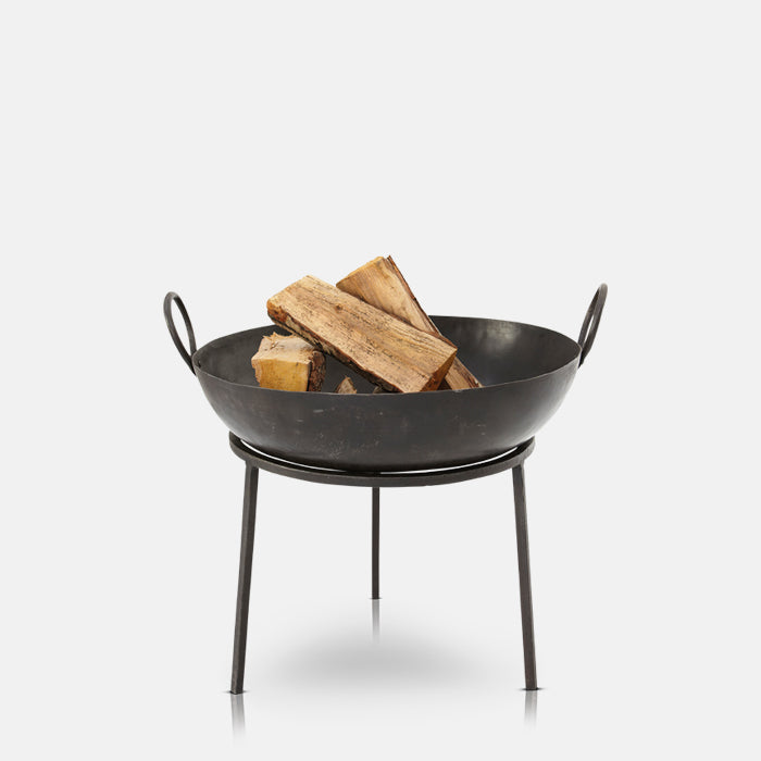 Round black metal fire pit filled with wooden logs