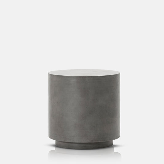 Tall, round brutalist side table made from concrete in grey