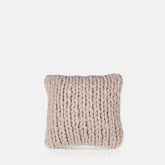 Square cushion with pale pink knitted cover.