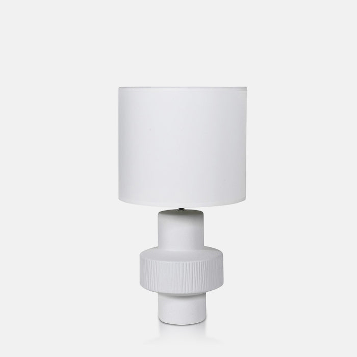 White table lamp with sculptural white ceramic base and white drum shade.