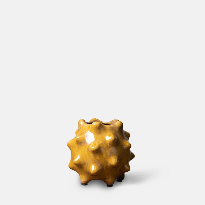 A cutout of the Otterley Stoneware Vase Honey, a small spiked textural vase in a warm honey colured glossy glaze.