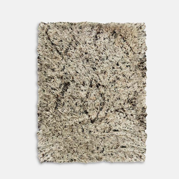 Deep pile shaggy wool rug with lozenge pattern design.