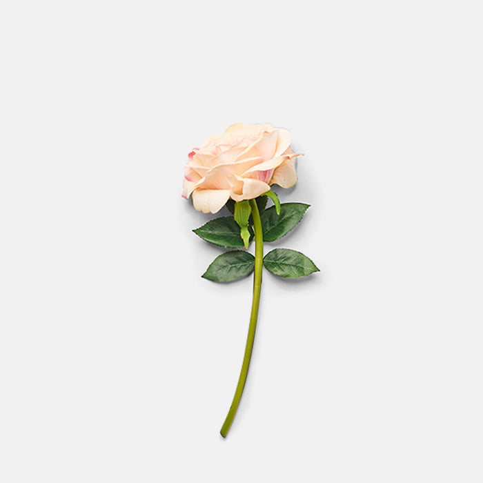 Artificial blush coloured rose on a green leafy stem