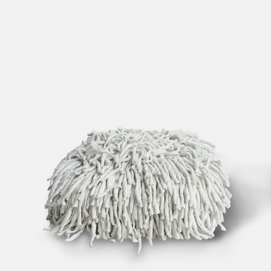 Shaggy wool pouffe in off-white colour.