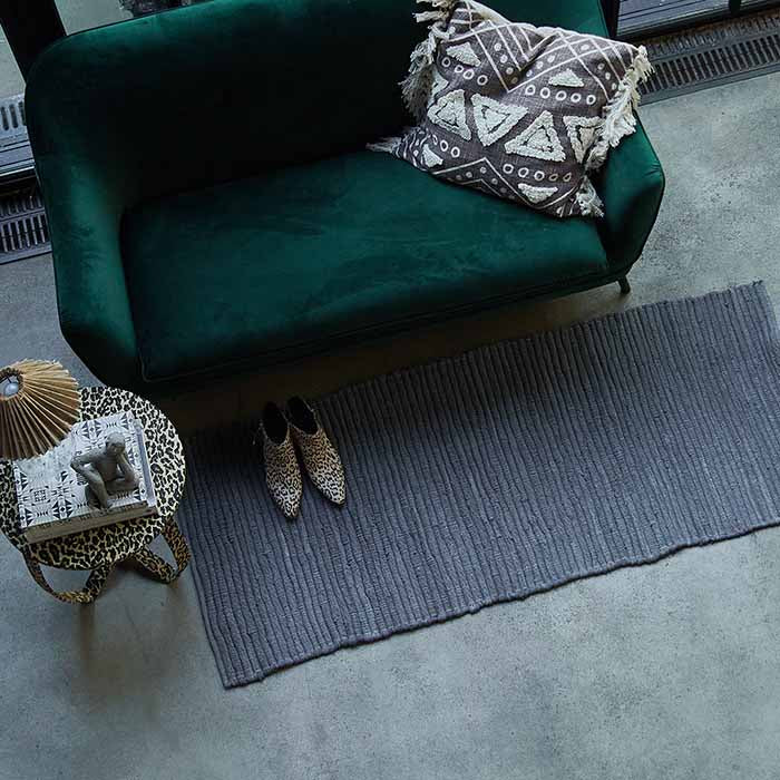 Grey runner next to a green two seater sofa and leopard print table