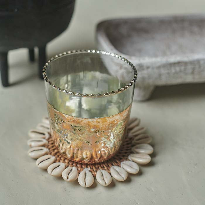 Clear glass candle holder with aged metallic body and silver rim.