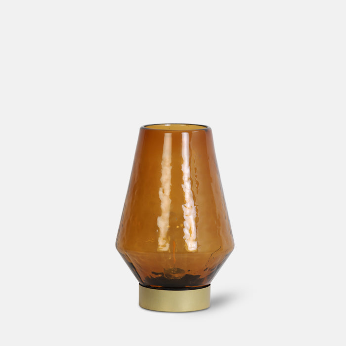 Wireless LED table lamp in amber glass with brass base.