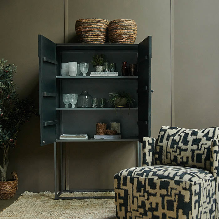 tall black cabinet with both doors open storing tableware pieces with two baskets on top